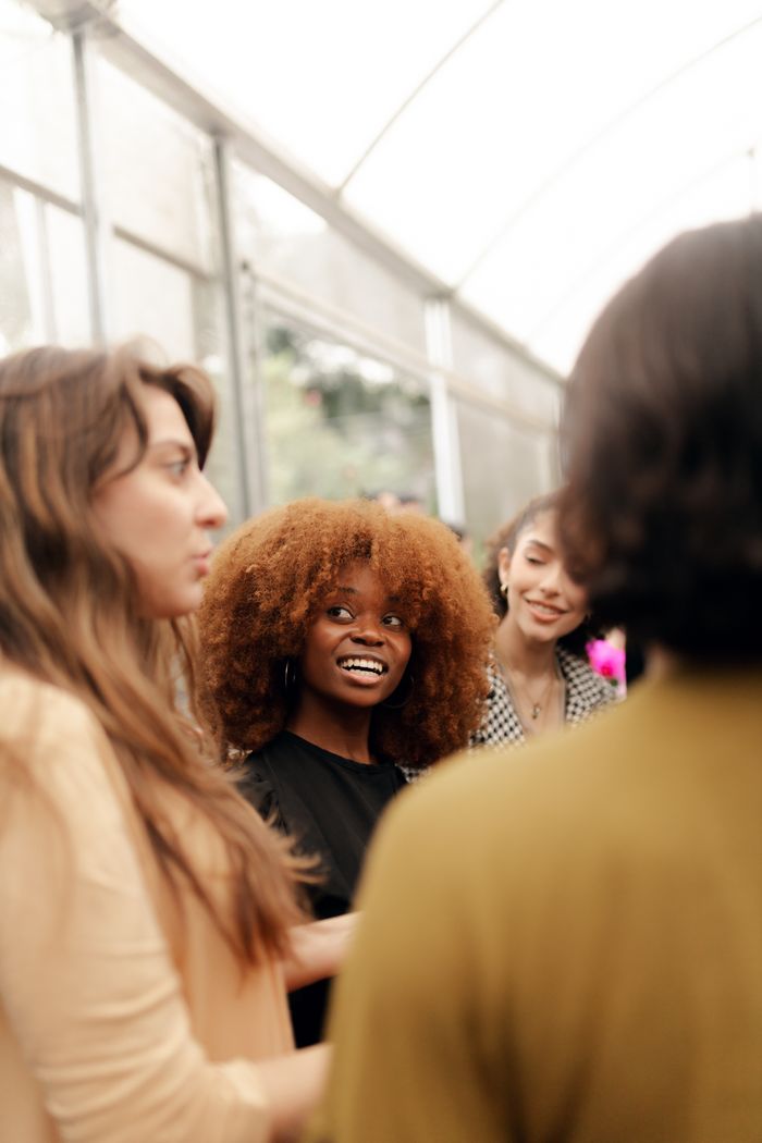Young adults having a lively discussion in a bright indoor space, showcasing diverse culture and friendship.